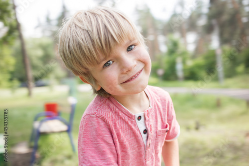 close-up portrait of a cute boy 5 years old walking in the park in the summer. Happy childhood, children, positive child photo