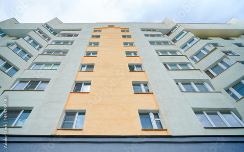 City apartment building on a background of blue sky. View from the bottom up