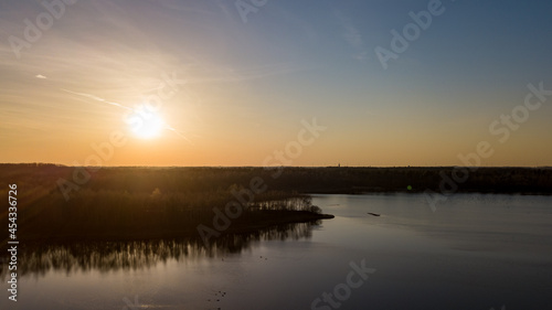 Aerial view shot by a drone of a beautiful dramatic and colorful sunset at coast of the lake. Nature landscape. Nature in Europe. reflection  blue sky and yellow sunlight. landscape during sunrise or