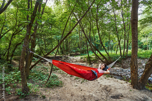 Happy young woman relaxing alone in forest