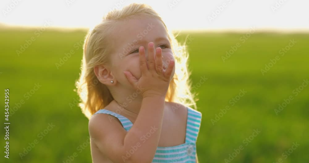 Niña pequeña adorable enviando beso al aire. Verano. Viento. Cámara lenta.