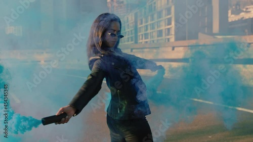 girl dancing with blue smoke grenade in city young rebellious woman celebrating creative expression with dance in street slow motion