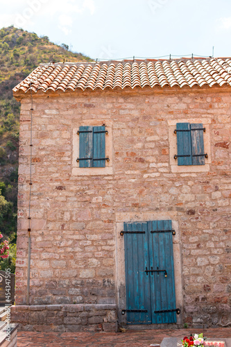 Windows with shutters on an old stone house, old architecture.
