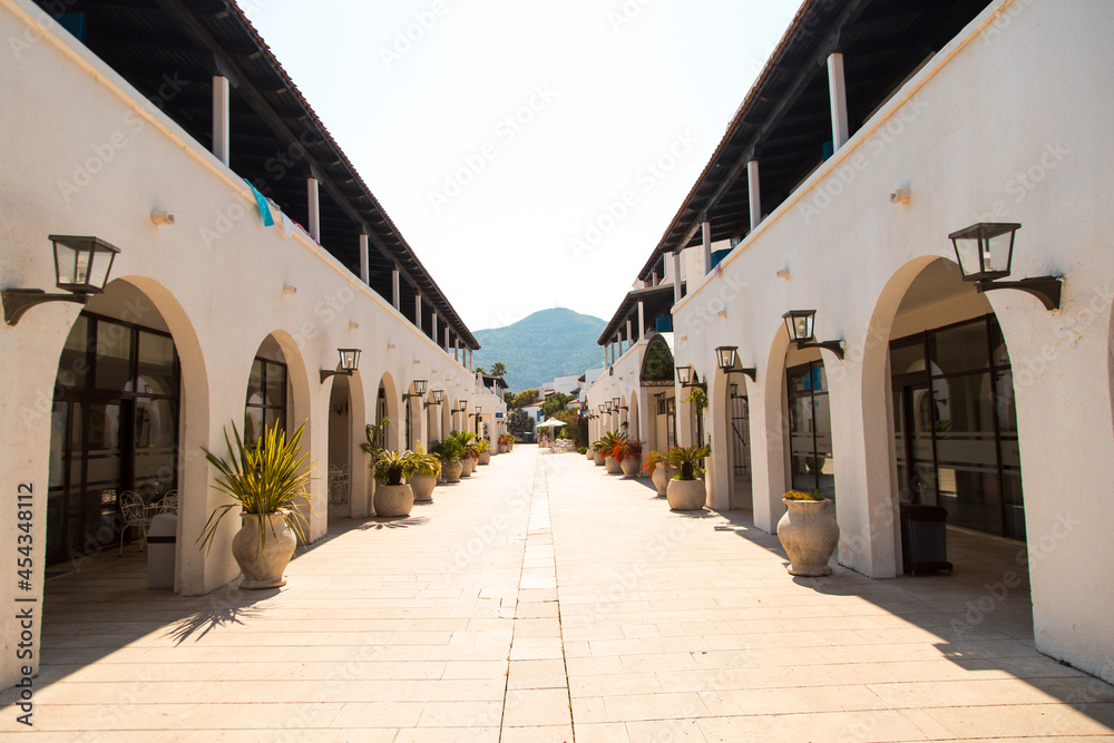 House, Hotel in Greek style, white walls, arches and flowers in pots.