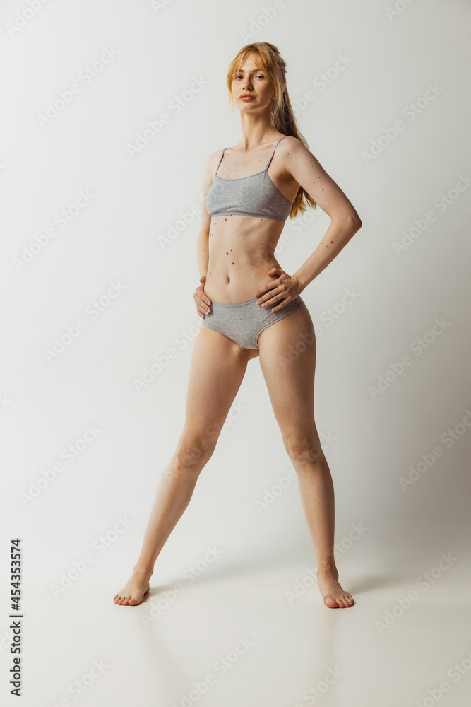 Portrait of young pretty, adorable woman in lingerie isolated over gray studio background. Natural beauty concept. Authenticity Portrait of young pretty, adorable woman in lingerie isolated over gray studio background. Natural beauty concept. Authenticity