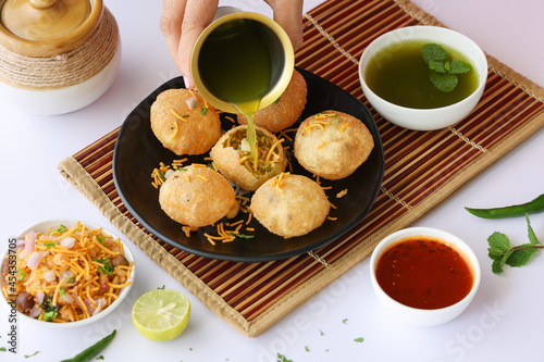 Girl women taking spicy Pani puri golgappe with hand, Chat item, India. North Indian street food  Indian panipuri snack eaten tangy tamarind water, potato stuffing Delhi, Mumbai, Holi Diwali Dussehra