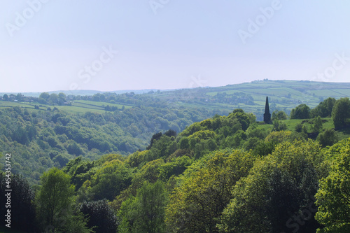 view of the valley and woodland looking over hardcastle crags with war memorial in calderdale west yorkshire