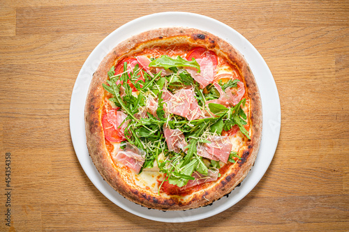 pizza with ham and rocket salad