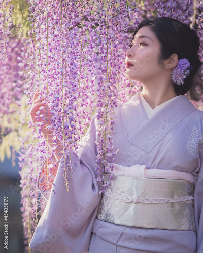 着物を着た女性と藤の花