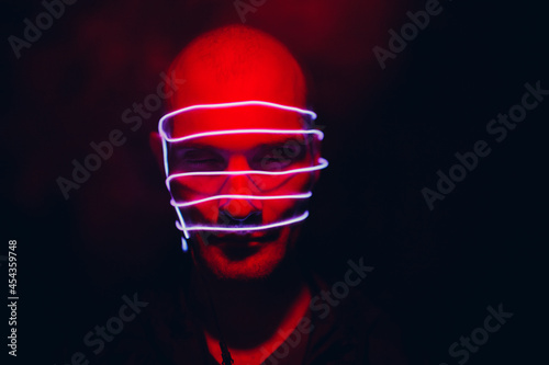 Portrait of man with neon glow lines on his face. Concept cyberpunk and virtual reality