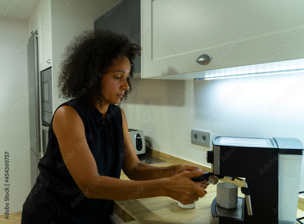 Colombian woman prepares coffee in her kitchen Colombian woman prepares coffee in her kitchen
