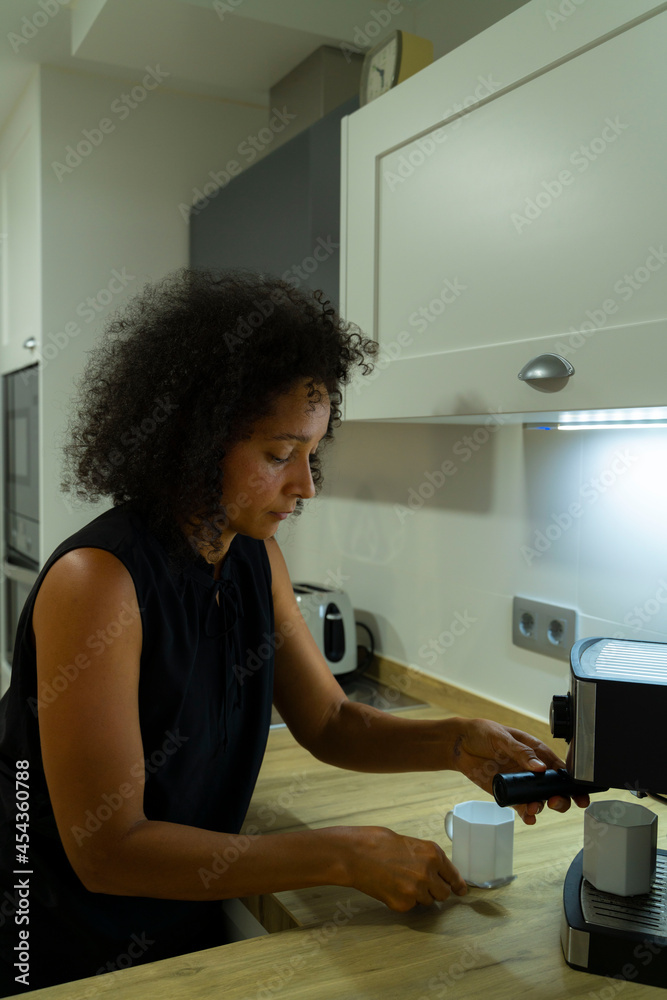 Colombian woman prepares coffee in her kitchen Colombian woman prepares coffee in her kitchen