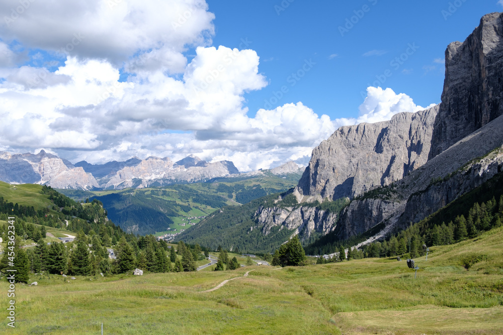 Alta Badia (Dolomiti) - August: Beautiful summer mountain view of Passo Sella and high peak Sassopiatto and Sassolungo, Langkofel, Dolomiti, Sella group. Green meadows and pastures, alpine dolomites