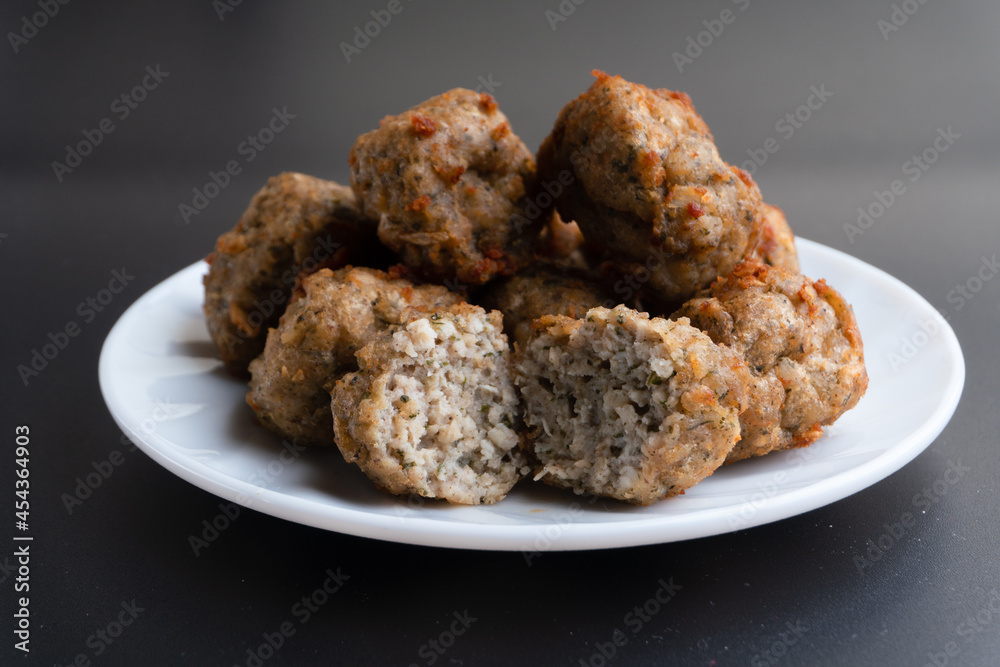 Chicken kofta meatballs mixed with ingredients of onions, garlic fresh herbs and spices mixture on black background