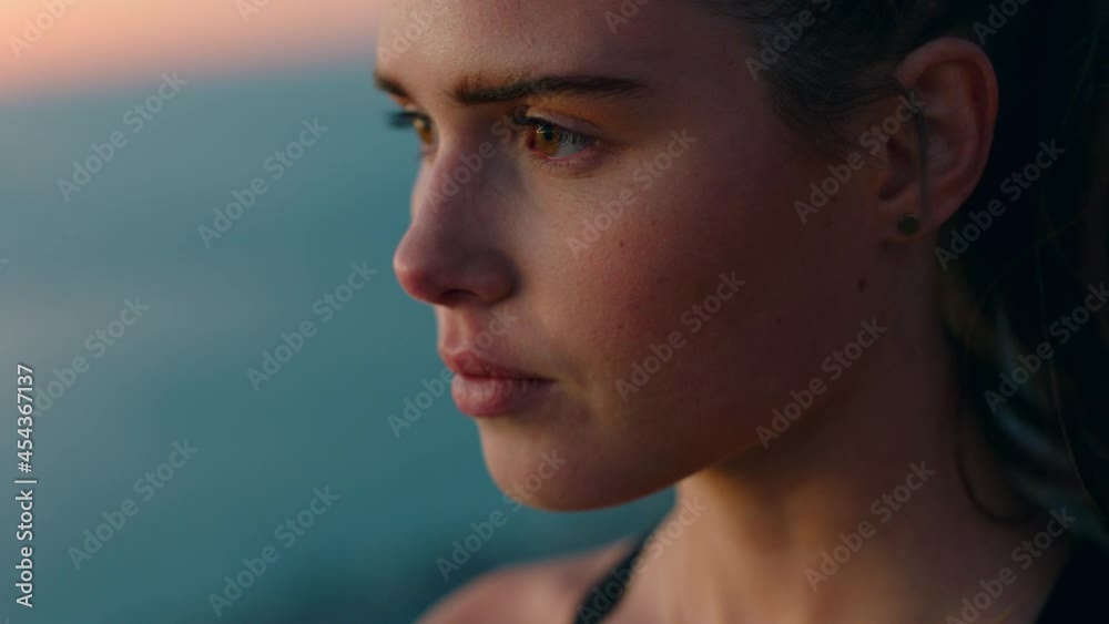 beautiful woman on mountain top looking at view of ocean at sunrise enjoying peaceful contemplation with wind blowing hair beautiful woman on mountain top looking at view of ocean at sunrise enjoying peaceful contemplation with wind blowing hair