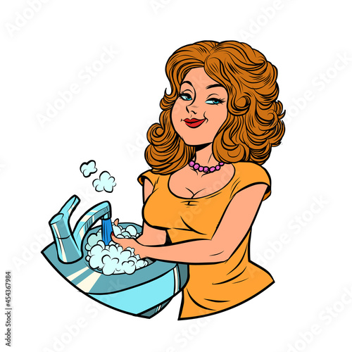beautiful young woman washes dishes, homework in the kitchen