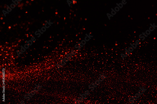 Small red glitter on dark black background