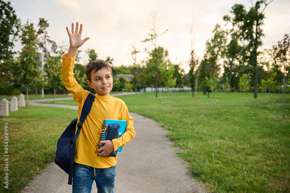 A handsome friendly charming schoolboy 9 years old, in the park, with a