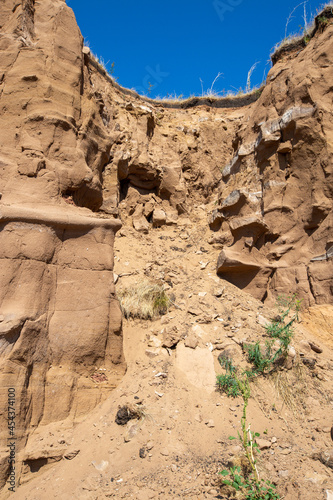 steep ravine slope, sandstone polished by wind and water erosion, stone texture