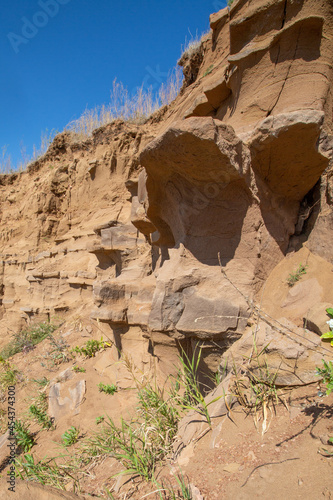 steep ravine slope, sandstone polished by wind and water erosion, stone texture