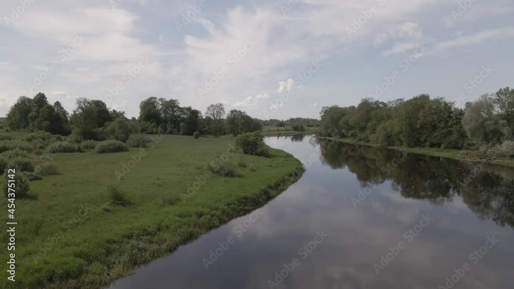 Static scene of a calm river flowing through meadows and forests in summer day Static scene of a calm river flowing through meadows and forests in summer day