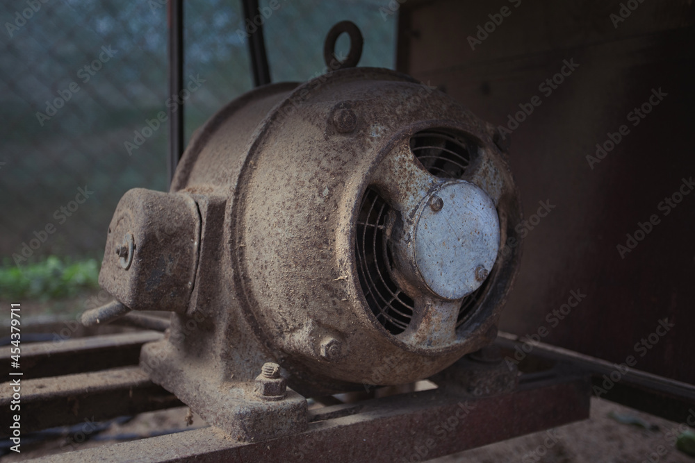 Old electric motor powering a table saw (bench saw). Vintage industrial equipment concept. Rusty and dirty electric engine power rotating machine Old electric motor powering a table saw (bench saw). Vintage industrial equipment concept. Rusty and dirty electric engine power rotating machine