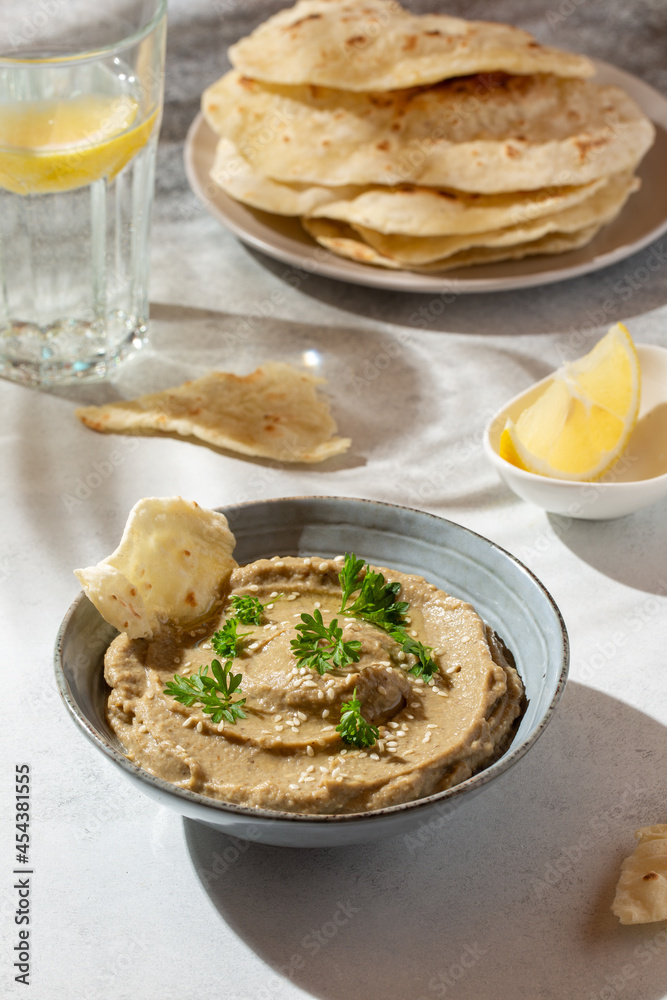 Baba ghanoush, babaganush or baba ganoush in gray bowl served with oriental flatbread on concrete background. Turkish cuisine. Baba ghanoush, babaganush or baba ganoush in gray bowl served with oriental flatbread on concrete background. Turkish cuisine.