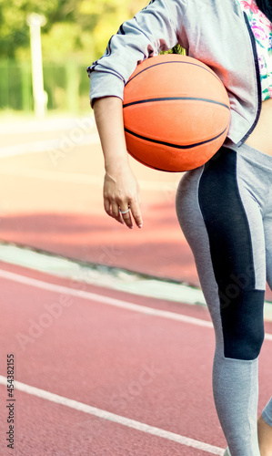 Beautiful fit young woman practicing basketball,holding ball standing in sportswear before training. © Berki Cosmin Alin