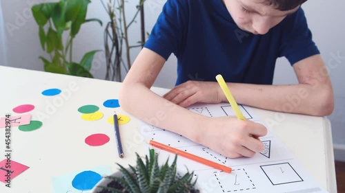 Close up Autism boy during therapy at home performs tasks for the development of the brain. Autism awareness concept. 4K, slow motion