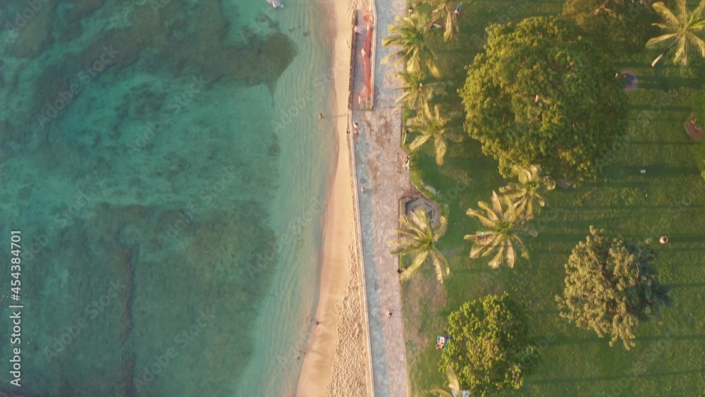 Aerial flight over a tropical beach. Cinematic video shooting. Aerial drone slowly flying over colorful landscape during sunset on Oahu island, Hawaii, with Waikiki beach.