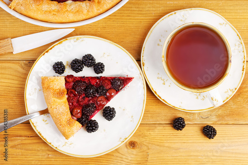 Piece of homemade open pie gallet with raspberries, blackberry and grapes. Top view. photo