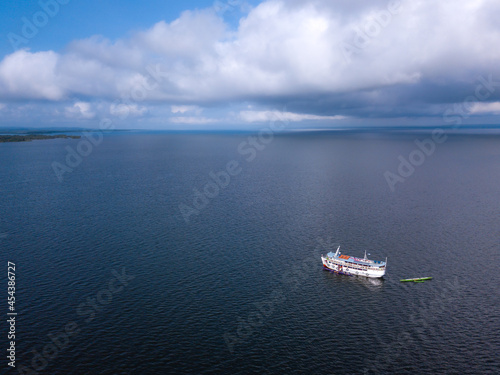 Beautiful aerial view of boat sailing on Tapajos River in Amazon Rainforest on sunny summer day. Alter do Chão, Para, Brazil. Concept of nature, conservation, environment, ecology, tourism, travel.