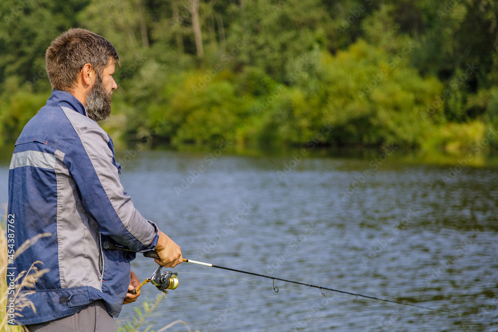 A man with a beard is fishing on the river. A fisherman with a fishing rod is fishing on the river bank. A man with a beard is fishing on the river. A fisherman with a fishing rod is fishing on the river bank.