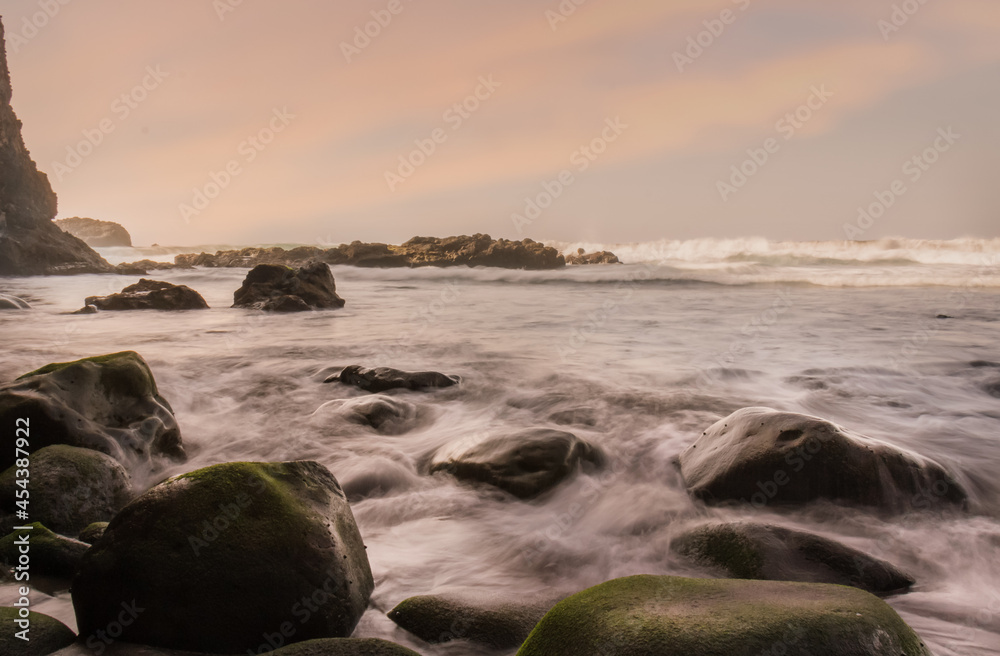 long exposure photo of the sea water between the rocks in the evening light