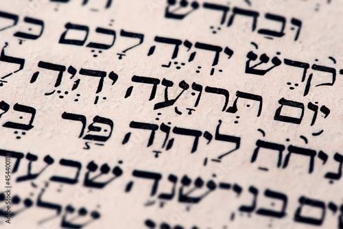 Obraz na płótnie Closeup of hebrew words Yom Teruah in Torah page that translate in english as Day of Trumpets - beginning of Rosh Hashanah, Jewish New Year. Biblical Jewish holiday. Selective focus. w salonie