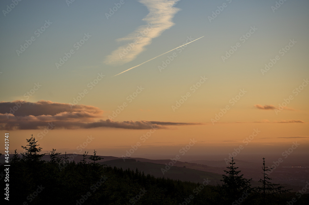 Beautiful orange sunset skies over hills in Dublin Mountains seen from Fairy Castle, Two Rock Mountain, Co. Dublin, Ireland. Golden hour gradients