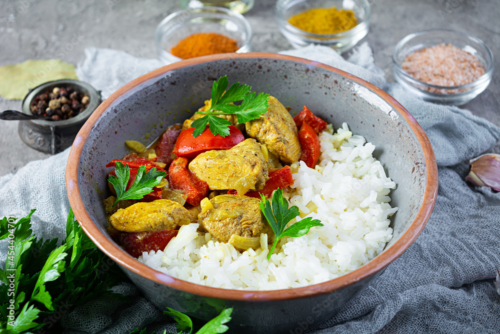Spicy chicken curry with rice. Curry sauce with chicken and rice on gray background Spicy chicken curry with rice. Curry sauce with chicken and rice on gray background