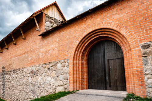 Wooden door in the castle of red bricks. © Natallia
