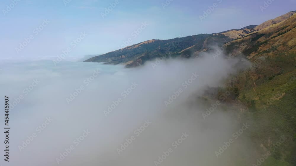 Beautiful aerial shot through the fog reveals the remote mountains along California's Highway One Pacific Coast Highway near Big Sur. Beautiful aerial shot through the fog reveals the remote mountains along California's Highway One Pacific Coast Highway near Big Sur.