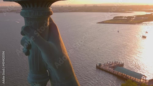 Extreme close up and tilt down at sunrise of the Statue Of Liberty landmark in New York harbor.