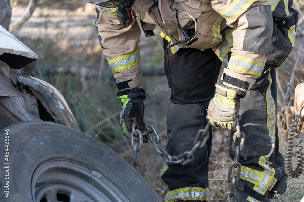 Fototapeta premium Firefighters rescuing fallen car in ditch.