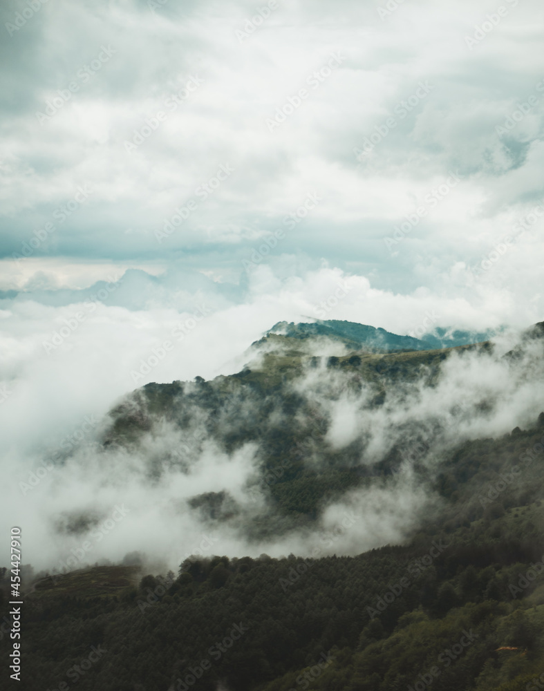 Mountain appears beneath the clouds on a cloudy day in Basque Country Mountain appears beneath the clouds on a cloudy day in Basque Country