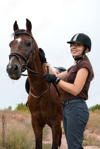 Portrait of a rider and her skewbald horse with a walk in nature