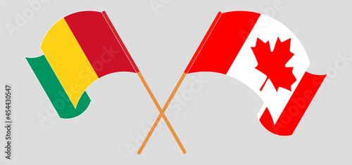 Crossed and waving flags of Guinea and Canada