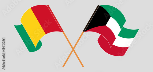 Crossed and waving flags of Guinea and Kuwait