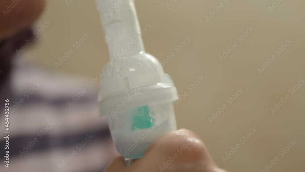 Nebulizer inhaler for cold and flue, asthma and bronchitis treatment, cure medical solution inside the aerosol device, woman inhaling steaming medical solution, breathing for open lungs. Asthmatic Nebulizer inhaler for cold and flue, asthma and bronchitis treatment, cure medical solution inside the aerosol device, woman inhaling steaming medical solution, breathing for open lungs. Asthmatic