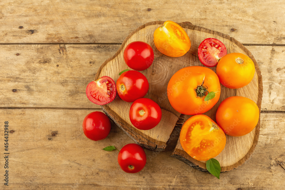 Assorted ripe tomatoes on a wooden stand. Fresh red and orange organic vegetables Assorted ripe tomatoes on a wooden stand. Fresh red and orange organic vegetables