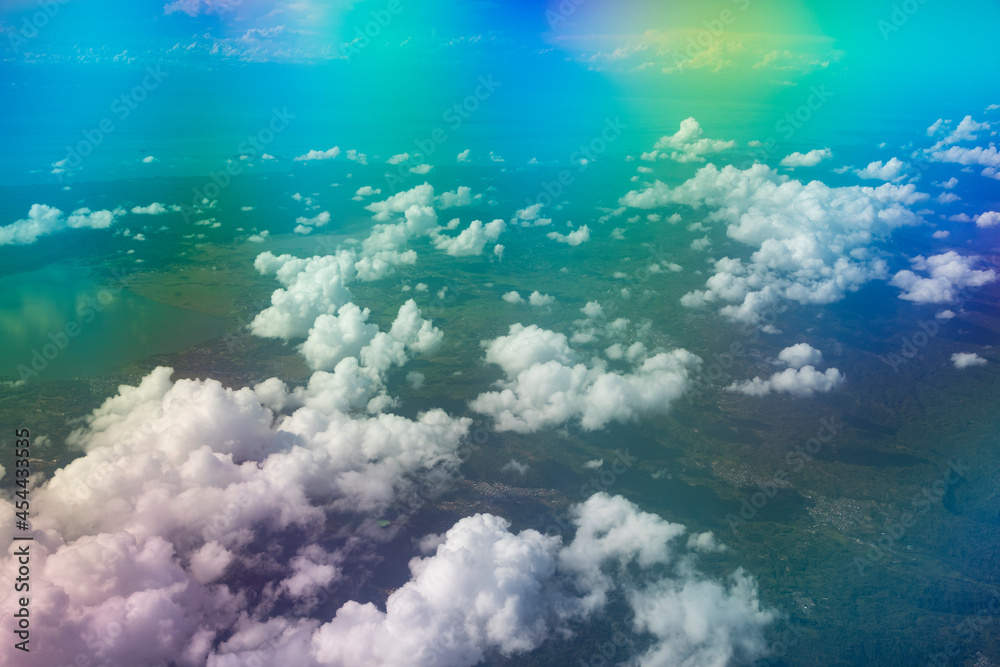 Naklejka premium Aerial view from the plane, with strange colors, of a landscape of clouds and distant islands, flying over the island of Sulawesi, Indonesia