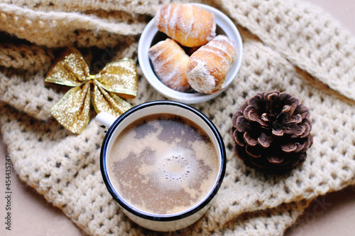 Still life. Breakfast. A cup of hot cocoa, biscuits, a golden bow and a bump on a knitted background