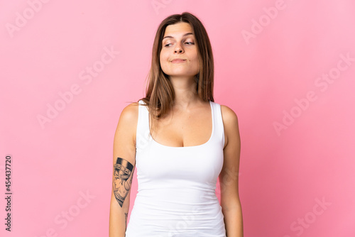 Young slovak woman isolated on pink background having doubts while looking side